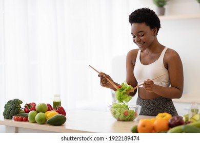 Weight Loss Nutrition. Side View Of Black Skinny Lady Cooking Vegetable Salad Standing In Modern Kitchen At Home, Preparing Healthy Dinner. Slimming Recipes, Dieting Concept. Copy Space