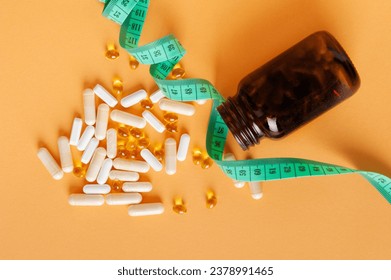 Weight Loss Pills Scattered from Bottle, Diet Supplements Capsules, Obesity Lose Tablets, Color Drugs Pile, Weight Loss Pills on Yellow Background with Copy Space for Text