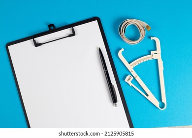 Weight Loss Plan At A Dietitian Nutritionist Doctor, Top View Of The Doctor's Desktop.Tablet For Notes And Caliper. Medical Concept