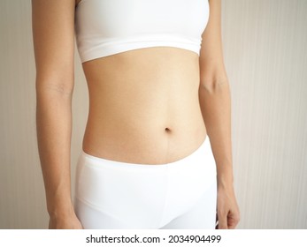Weight loss and slim body in woman and belly fit firmming use for workout, fitness or diet and burn or detox on white background. closeup photo, blurred. - Shutterstock ID 2034904499