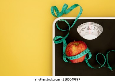 Weight scale and measure tape with fresh apple , Healthy diet for weight loss control concept - Shutterstock ID 2185049999