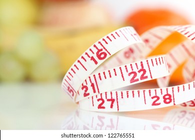 Weight watcher - Measuring tape with different fruits at the background (V-Format ID 174374312) - Powered by Shutterstock