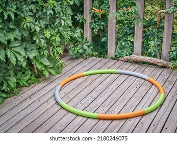 Weighted Hula Hoop On A Wooden Backyard Deck In Summer Scenery, Core Workout Concept