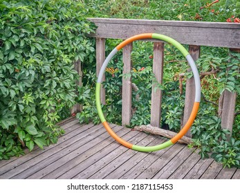 Weighted Hula Hoop On A Wooden Backyard Deck In Summer Scenery, Core Workout Concept