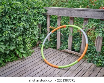 Weighted Hula Hoop On A Wooden Backyard Deck In Summer Scenery, Core Workout Concept