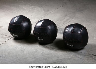 Weighted Med Ball At Gym On The Ground, With Nobody. Dark Background.