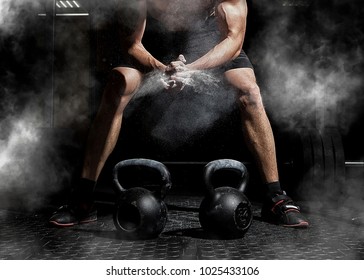 Weightlifter clapping hands and preparing for workout at a gym. Focus on dust - Shutterstock ID 1025433106