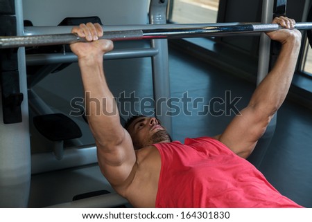 Weightlifter On Bench press. Young Men In Gym Exercising On The BenchPress