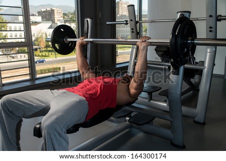 Weightlifter On Benchpress. Young Men In Gym Exercising On The Bench Press
