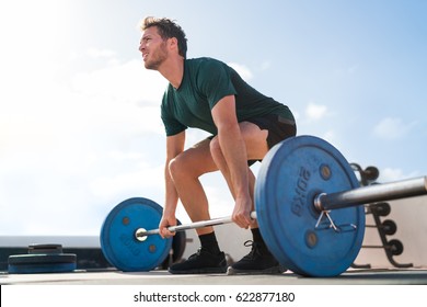 Weightlifting fitness man bodybuilding or powerlifting at outdoor gym. Bodybuilder doing barbell weight workout deadlift with heavy bar.