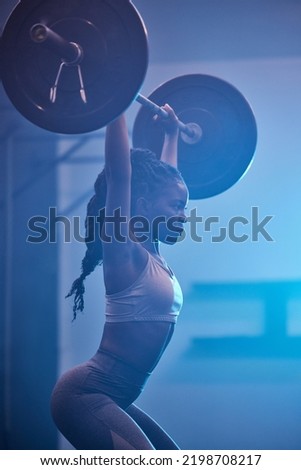 Weightlifting focus, motivation and fitness workout mindset of woman lifting weights at a gym. Female from Kenya working out, sports exercise and strong sport training at a health and wellness club