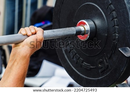 Weightlifting. The process of bench press with the wrong grip. Inept handling of the barbell during the exercise. Close-up. unrecognizable person