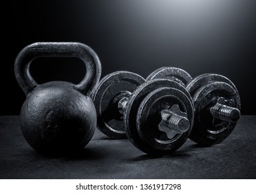 Weights and dumbbells on a black background - Powered by Shutterstock