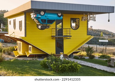 Weird upside down house. Bizarre wooden home. Funny architecture