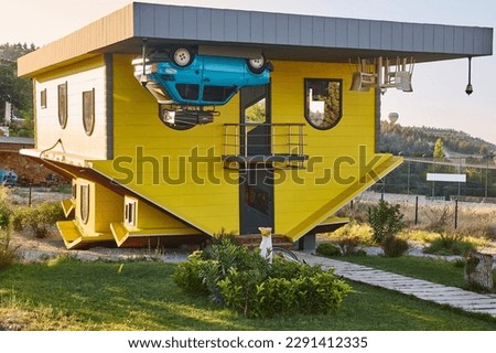 Weird upside down house. Bizarre wooden home. Funny architecture