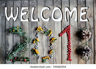 Welcome 2018 text New year on wooden background with seasonal greenery and colored berries - Powered by Shutterstock