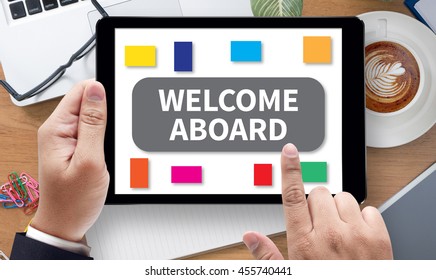 WELCOME ABOARD, on the tablet pc screen held by businessman hands - online, top view