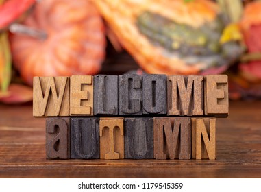 Welcome Autumn Message Written In Wooden Block Letters With A Fall Background Theme