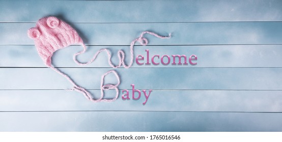 Welcome baby girl on wood background. Baby shower, birthday, invitation or greeting card idea.