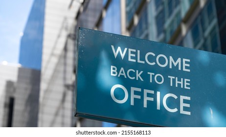 Welcome Back To The Office On A Blue City-center Sign In Front Of A Modern Office Building	