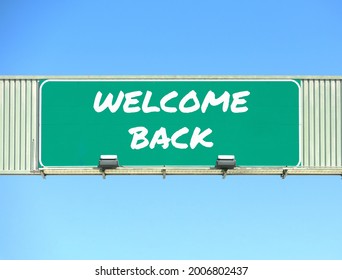 Welcome Back Sign On Interstate Highway Overhead Road Sign. Blue Sky Background