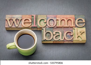 Welcome back sign - text in letterpress wood type with a cup of coffee