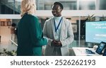 Welcome booth, conference and summit with business people at expo for tradeshow, information or showcase. Product exhibition, brochure and networking pitch with employee at seminar for workshop event