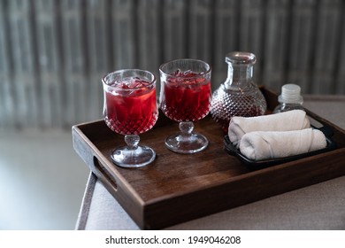 Welcome Drink Red Mocktail And White Towel Served On Wooden Tray.