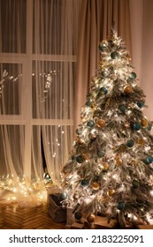 Welcome Home Christmas Tree. Window With Decorated Glowing Christmas Tree Inside House, Night Scene, Blurry Light. Christmas And New Year Holidays Background.