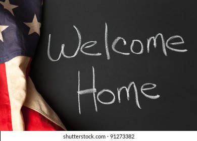 Welcome Home Sign On A Chalkboard With Vintage American Flag