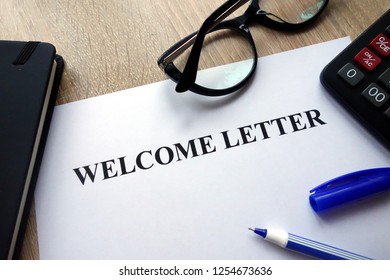 Welcome Letter, Pen, Glasses And Calculator On Desk