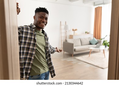 Welcome To My House. Cheerful Black Man Opening Door And Gesturing Inviting To Come In And Showing His Living Room Smiling To Camera Standing At Home. Real Estate Ownership And Hospitality