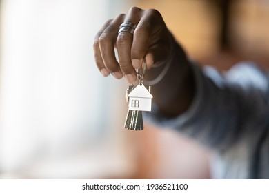 Welcome to new house. Close up of young african american man hand hold bunch of keys. Cropped shot of black guy real estate agent realtor give offer you client key from home flat apartment. Copy space