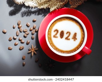 Welcome new year 2024 holidays food art theme coffee cup with number 2024 over frothy surface serve on red saucer flat lay on wooden table background with coffee beans, star anise, dried pine branch. - Powered by Shutterstock