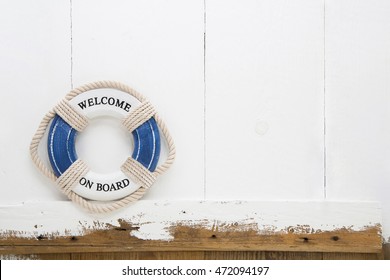 Welcome On Board Lifebuoy On White And Blue Old Wooden Background For Concepts.