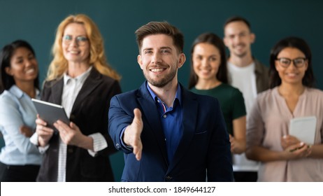 Welcome On Board. Portrait Of Positive Confident Millennial Male Hr Manager Leader Of Multiethnic Team Looking At Camera Extending Hand For Handshake Greeting New Staff Member Inviting Newbie To Join