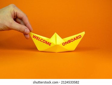 Welcome onboard and support symbol. Concept words Welcome onboard on yellow paper boat on a beautiful orange table orange background copy space. Businessman hand. Business and Welcome onboard concept.