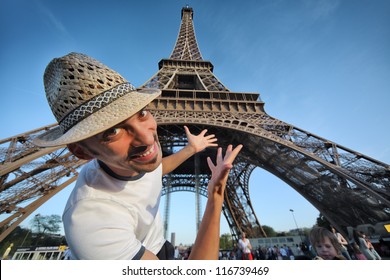 Welcome to Paris! Happy smiling tourist pointing to Eiffel Tower in Paris, France.