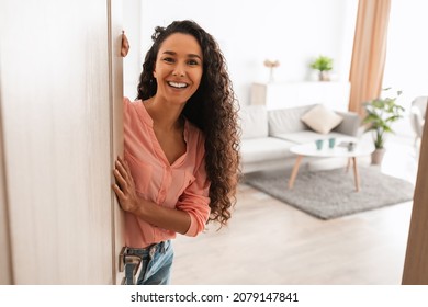Welcome. Portrait of cheerful woman standing in doorway of modern apartment, greeting visitor and inviting guest to enter her home, happy smiling young lady holding door looking out flat - Shutterstock ID 2079147841