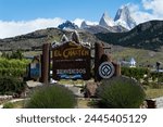 welcome sign to El Chaltén, with Fitz Roy mount in the background. Sign Translation: El Chalten. National Capital of Trekking. Welcome