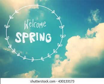 Welcome spring text on blue sky and cloud background