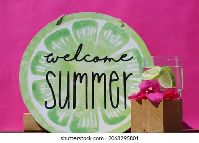 Welcome Summer Sign And Glass With Lemon On Pink Background.