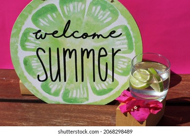 Welcome Summer Sign And Glass With Lemon Slice On Pink Background. 