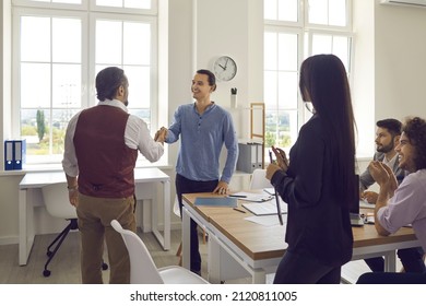 Welcome To Team. Senior Business Manager Shakes Hands With A Young Cheerful Man, Welcoming Him As A New Team Member. Manager Is Satisfied With The Results Of The Interview And Hires A Young Candidate