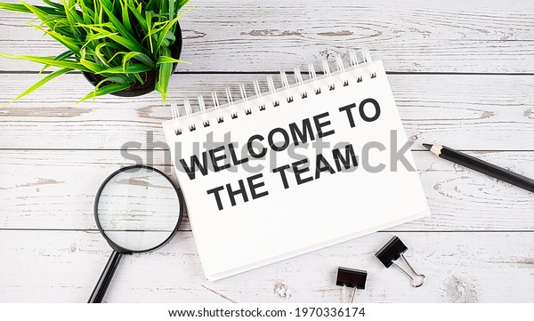 WELCOME TO TEAM text concept write on notebook\
with office tools on wooden\
background