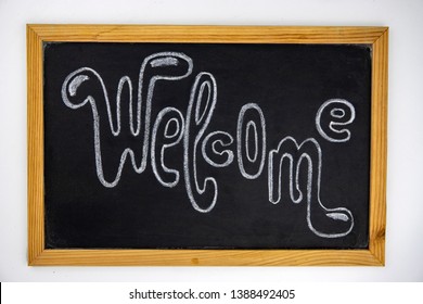 Welcome white chalk lettering inscription on blackboard. School chalkboard with Welcome sign on white background. Welcome lettering on frame board top view photo. Back to school message flat lay - Powered by Shutterstock