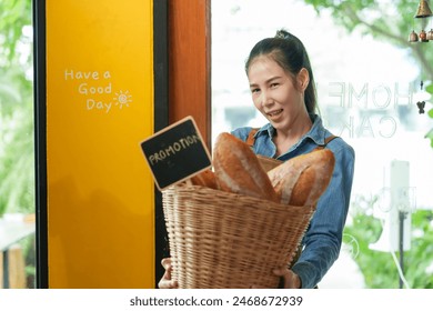 Welcoming Asian woman bakery staff with a basket full of fresh bread, exemplifying small business charm. happiness of opening a coffee shop in the morning small family business - Powered by Shutterstock