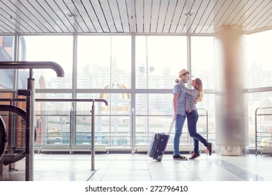 Welcoming Embrace. Young Loving Couple Hugging In The Airport Terminal.