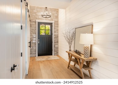 Welcoming entry interior with large wooden and glass doors hardwood and tile floors staircase
