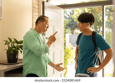 Welcoming son home, father smiling and talking, standing near doorway with suitcase. Family, reunion, homecoming, happiness, fatherhood, luggage - Powered by Shutterstock